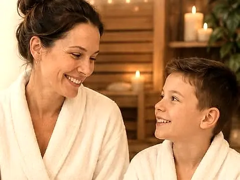 Mama in sin v kopalnih plaščih se nasmejana gledata